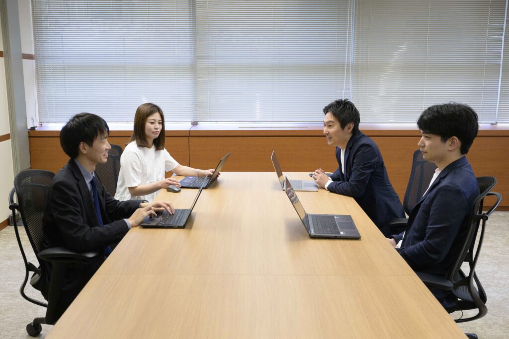 写真：会議室で会話している4名