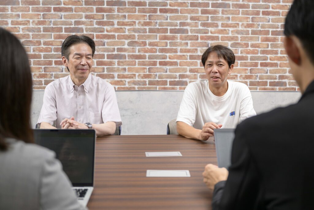 写真：成果について笑顔で話すNTTデータルウィーブ阿部さんと岩崎さん