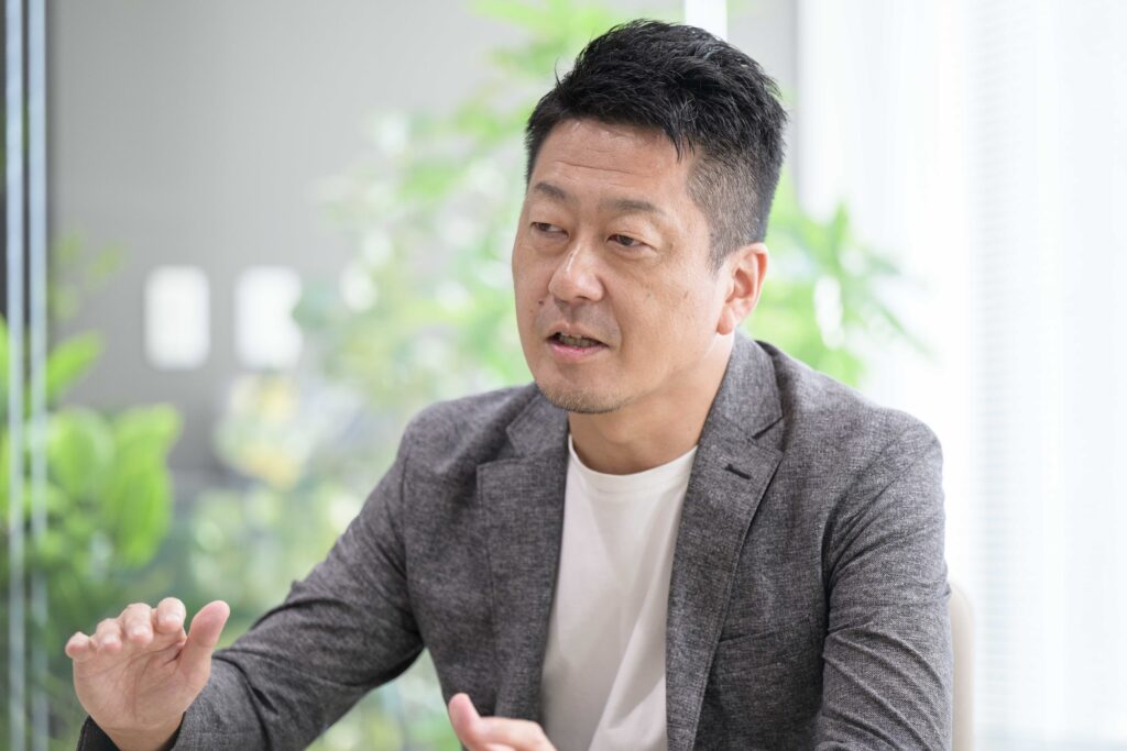 写真:インタビューに応じるユニアデックス八巻さん