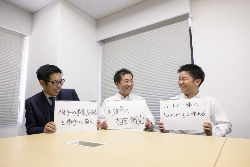 3名がフリップを見せながら、インタビューの終わりに語っているところ