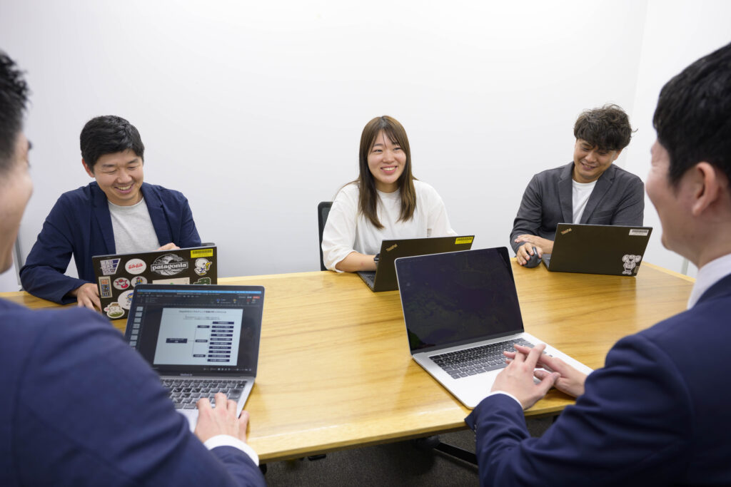 取材の様子。UPDATERのみなさんと才流のコンサルタントがテーブルを囲み、笑顔で語り合う