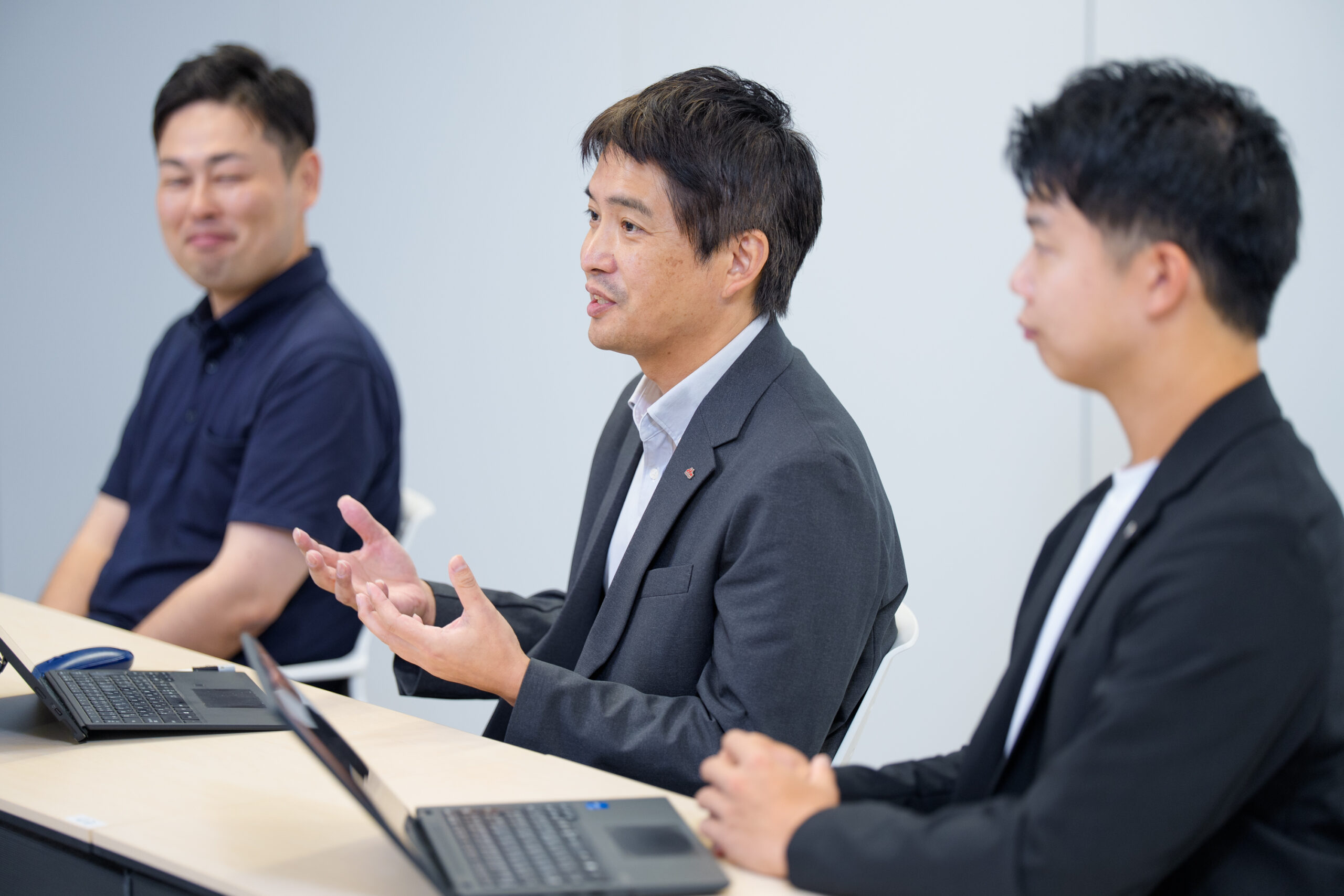 森永乳業の3名が並んでおり、真ん中に座っている長谷川さんが話をしている。二人は真剣に耳を傾けている様子