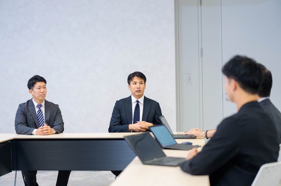 才流２名と森永乳業の方がL字型のテーブルで対している様子。